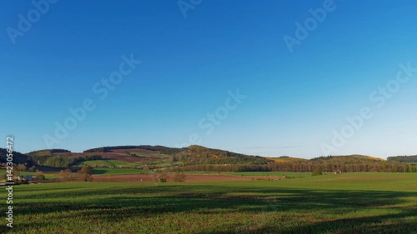 Fototapeta Glenduckie Hill seen from Dunbog Hamlet, with long evening shadows being cast across the fields on a bright April Evening.