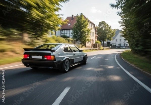 Fototapeta Vintage Silver Car Driving Fast on Road with Trees and Houses
