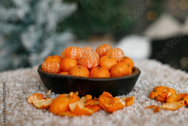 Obraz Fresh tangerines in a plate on a table with lights 