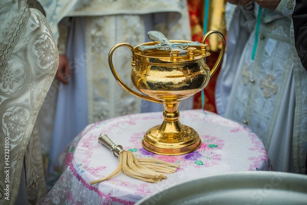 Fototapeta Priests standing near a container of water, praying, preparing water for sprinkling, lighting pilgrims with holy water