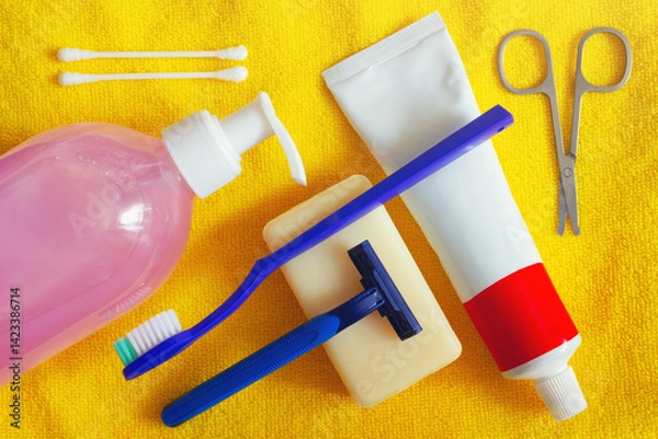 Fototapeta The hygienic set for daily usage. The personal care accessories on yellow towel background.