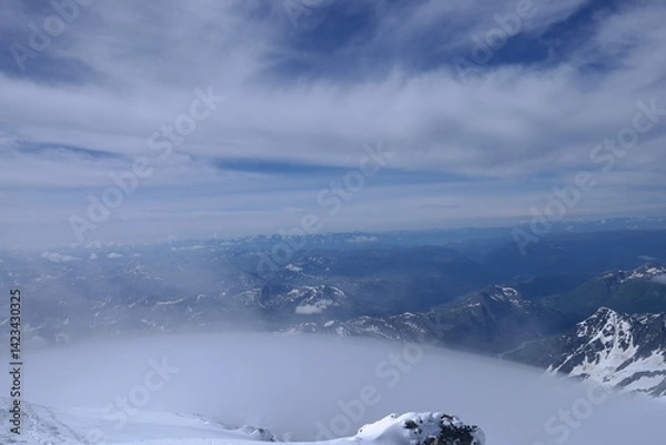 Fototapeta Tranquil Lake With Lush Green Forest, Snow-Capped Mountain, Blue Sky And White Clouds