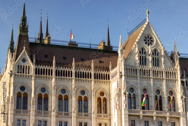 Fototapeta Detailed exterior views of the Hungarian Parliament Building in Budapest showcasing neo-Gothic architecture, pointed spires, arches, and ornate stonework