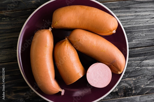 Fototapeta Sausages on a wooden background in rustic style