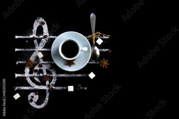 Fototapeta Concept of a cup of coffee on a black background with spices and sugar