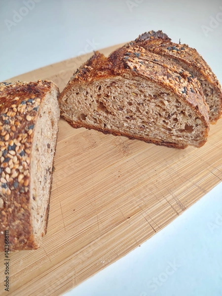 Fototapeta freshly cut artisanal sourdough bread showing crumb and texture on a rustic wooden surface