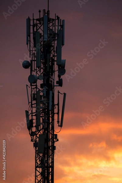 Obraz Silhouette of a telecommunications antenna, mobile phone, at sunset, in the city of Pakse, Laos