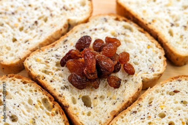 Obraz A pile of dried raisins on stacked slices of bread close up