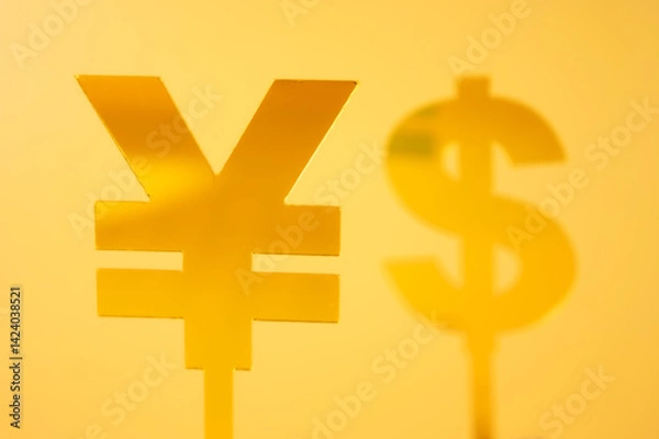 Fototapeta Two yellow currency symbols, the Chinese Yuan (¥) and Dollar ($), set against a bright yellow background