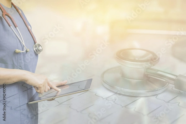 Fototapeta Female doctor,surgeon holding using tablet pc computer at work,Healthcare And Medicine,during the conference on blurred background ambulance speeding through the streets.in vintage color