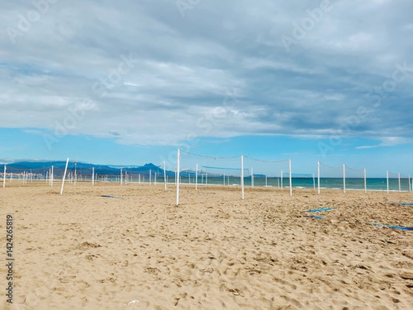Fototapeta Empty Beach Volleyball Courts Facing the Sea Under a Cloudy Blue Sky