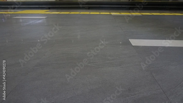 Fototapeta Cigarette ash floor with yellow disabled track at train station
