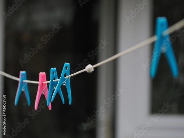 Obraz Close up of some colourful plastic, clothes pegs on a washing line
