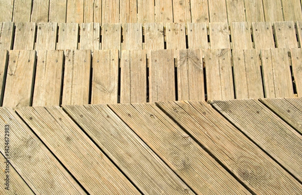 Fototapeta Section of a weathered wooden staircase, its planks showing signs of wear and arranged in a parallel pattern