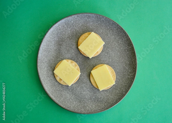 Fototapeta Extra tasty cheddar cheese slices on cracker biscuits. 