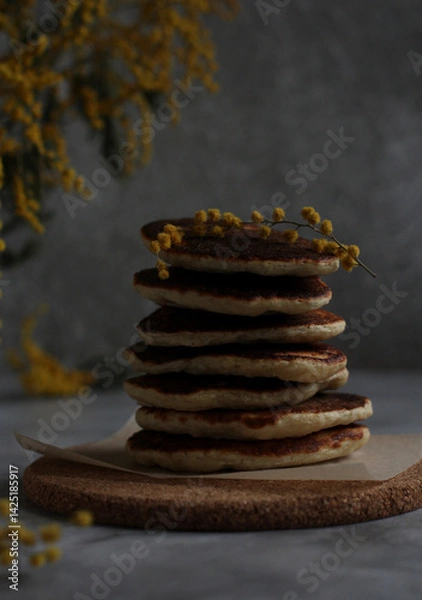 Fototapeta pancakes in rows in a close-up with mimosa on a gray background