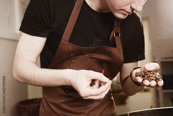 Fototapeta Barista holding freshly roasted coffee beans in hands