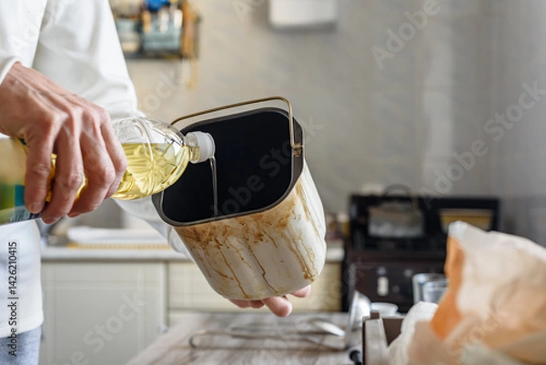 Obraz Closeup photo of man buttering bread making form with oil. Home bread baking with ingredients, oil, and dough in a form, ready for the fryer