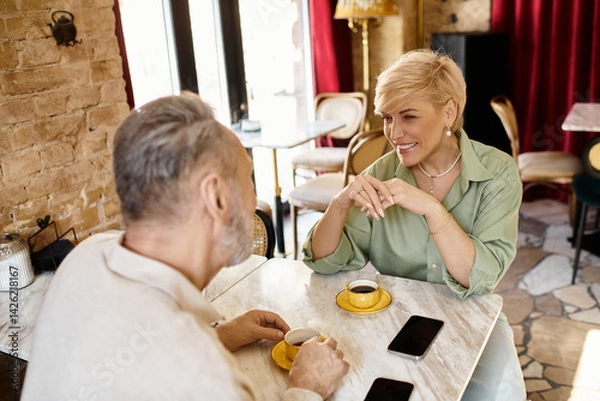 Fototapeta Romantic moments shared by a mature couple at a cozy cafe in the afternoon light
