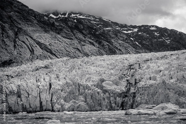 Fototapeta Cold sloping land and low clouds over Dawes Glacier in Alaska