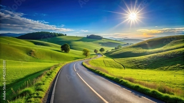 Fototapeta Asphalt road winding through vibrant green rolling hills under a bright sun
