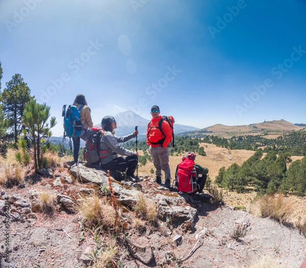 Obraz Hikers resting and enjoying the view of popocatepetl volcano in mexico