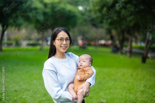 Obraz Mother holding newborn baby in park during daytime