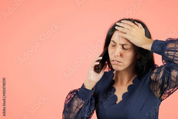 Obraz Young woman upset about the conversation she's having on her cell phone. An entrepreneur is worried and angry because the meeting with the client didn't go well.