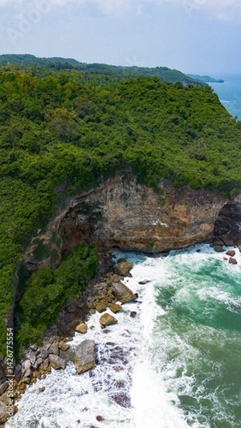 Obraz Aerial view of the coast, rocky cliffs and green forests located in Gunung Kidul, Yogyakarta, Indonesia