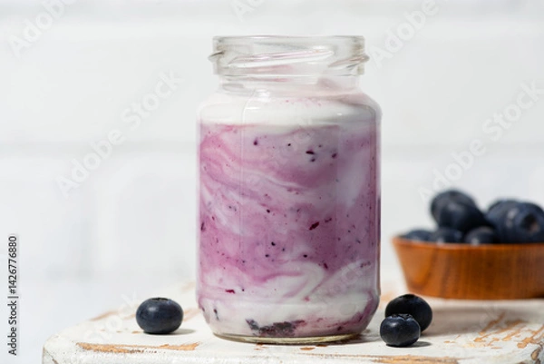 Obraz fruit yogurt with blueberries in a glass jar, closeup