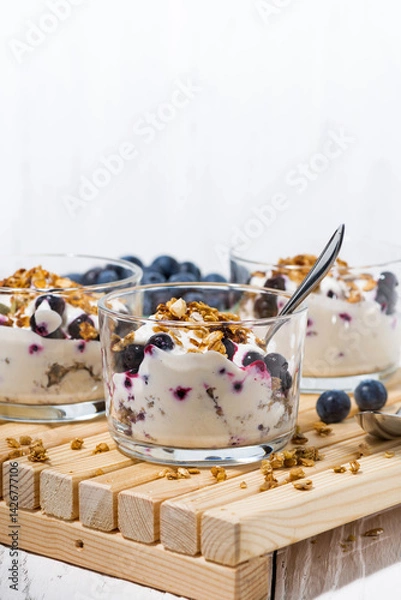 Obraz glasses with healthy dessert with blueberries, yogurt and muesli, vertical
