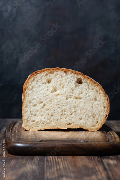 Obraz half of white bread on a wooden cutting board