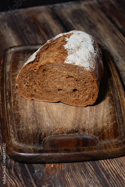 Obraz half rye bread on a wooden cutting board, top view