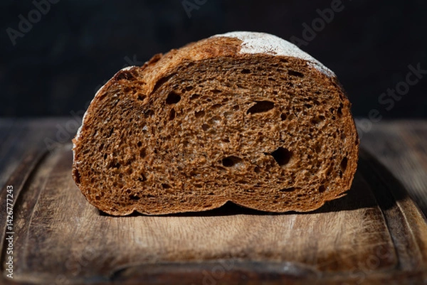 Obraz half rye bread on a wooden cutting board, close-up