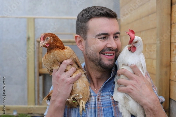 Fototapeta Man holding a pair of hens 