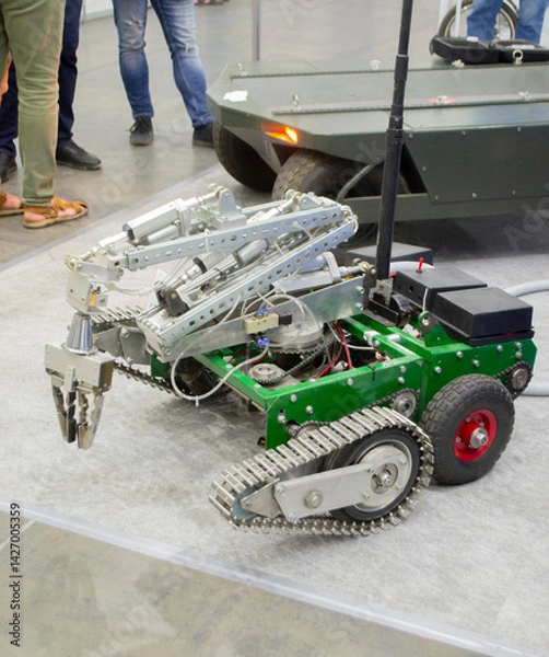 Fototapeta Small robot car unmanned with a crane and on tracks. Robotization robotics