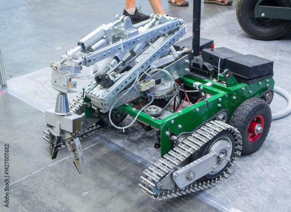 Fototapeta Small robot car unmanned with a crane and on tracks. Robotization robotics