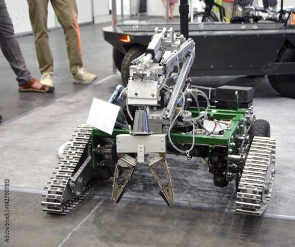 Fototapeta Small robot car unmanned with a crane and on tracks. Robotization robotics