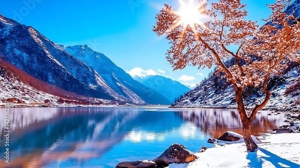Obraz Serene Winter Landscape Snowcapped Mountains CrystalClear Lake and a Solitary Tree Basking in Sunlight