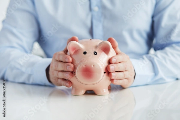 Fototapeta Man with piggy bank on the table