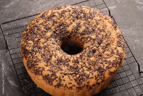 Fototapeta Sponge cake sprinkled with chocolate on a cooling rack.