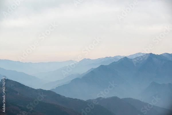 Fototapeta 겹겹이 쌓여있는 안개 낀 산능선.