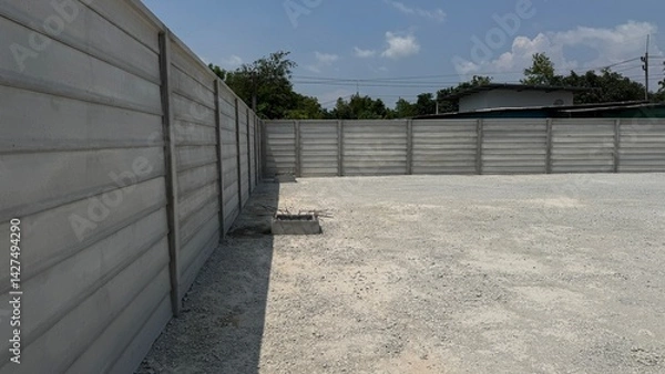 Fototapeta Concrete Wall Boundary: A study of a constructed concrete wall in an open outdoor space. Emphasizing on security, protection, and structure.