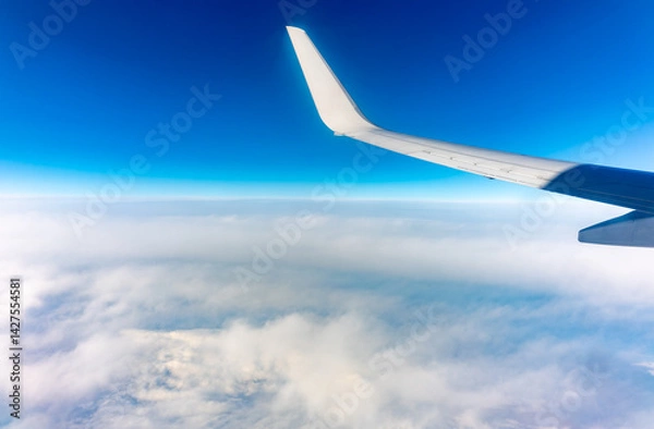Fototapeta View from the airplane window at a beautiful cloudy sky and the airplane wing