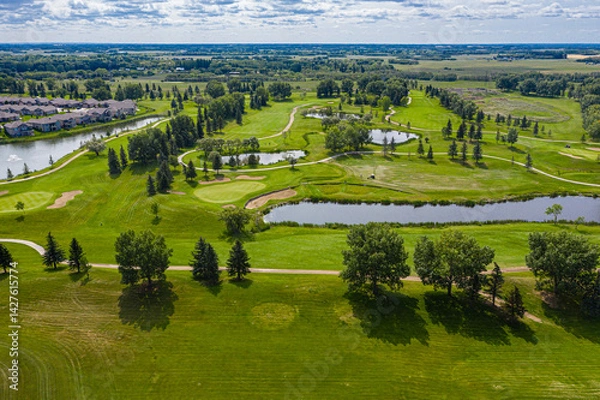 Fototapeta Golf course with a lake in the background