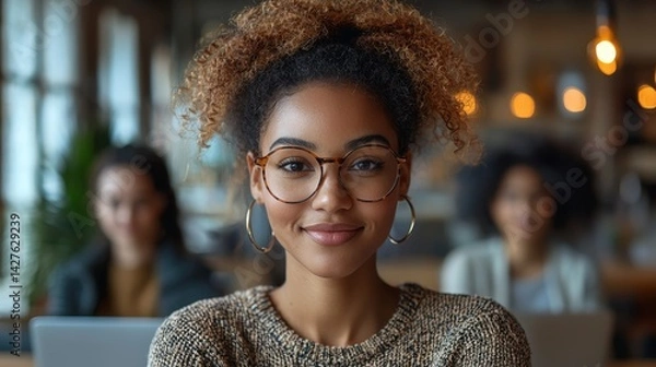 Obraz Confident and stylish young Afro American woman relaxing in the cozy atmosphere of a coffee shop working on her laptop with a warm positive mood