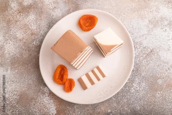 Fototapeta Cocoa and milk jelly with dried apricots on brown concrete background, top view, copy space