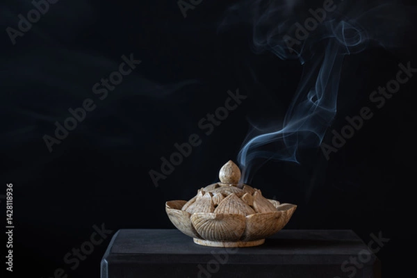 Fototapeta Stone carved incense burner on a black background.