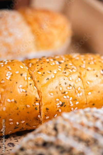Obraz Soft Brownish Bread With Filling Sprinkled With Sesame Seeds. Looks Very Aesthetic And Appetizing.