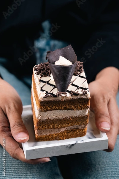 Obraz A Slice Of Cake Topped With Chocolate On Top With An Elegant Background Looks Aesthetic And Very Appetizing.